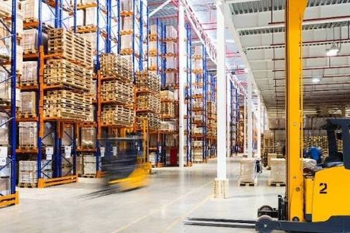 Warehouse aisles with pallet racks and a forklift, annotated with a demand forecast, an early restock and a model recommendation to move stock to Zone A